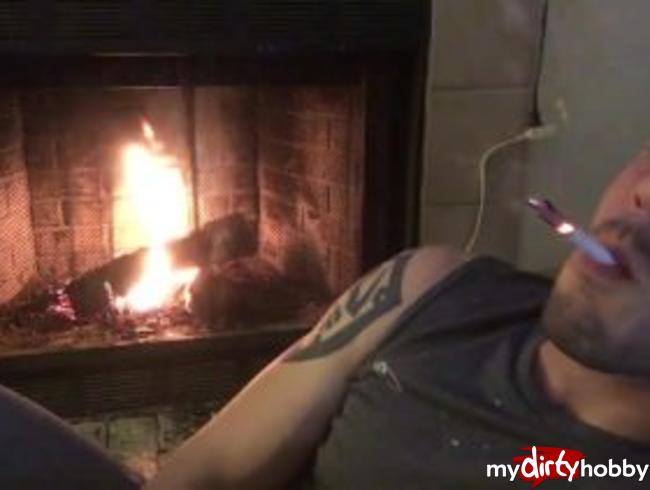 Jock flexes and chain smokes in front of his fireplace